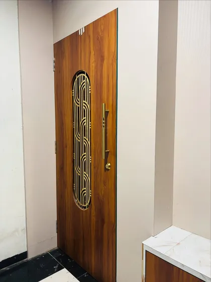A view of the finished wooden safety door with the brass grill, installed neatly within the entranceway.