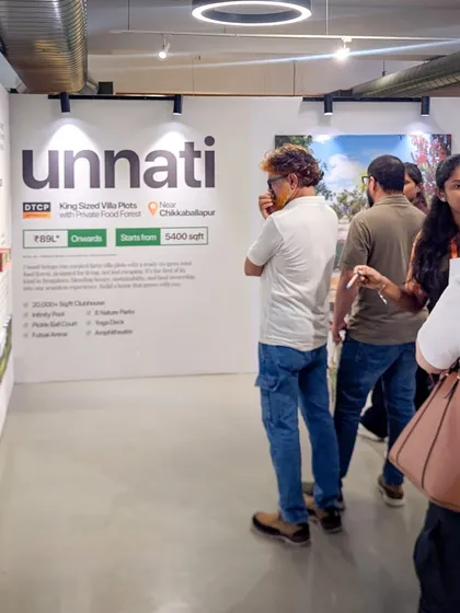 A visitor at the Farm Expo looking at the details of our Unnati villa plots.