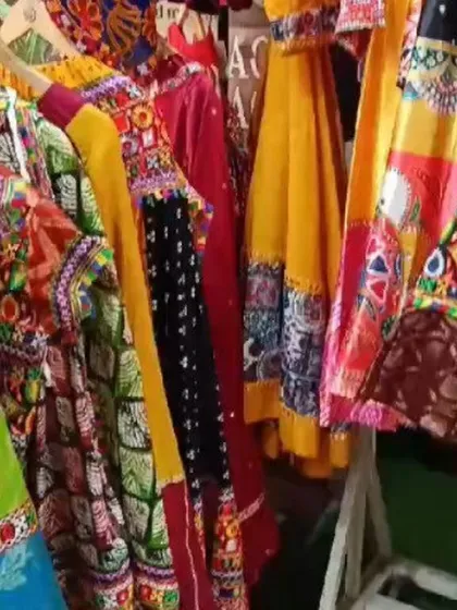 A rack filled with vibrant, ready-to-wear dandiya dresses, featuring a mix of colors, prints, and traditional Gujarati embroidery.