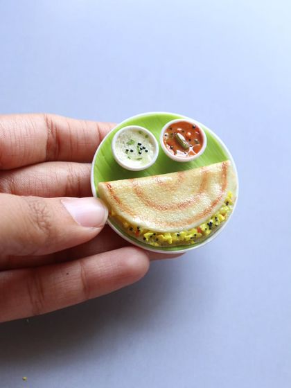A close-up of a mini masala dosa magnet, showing the crispy texture and the delicious filling.