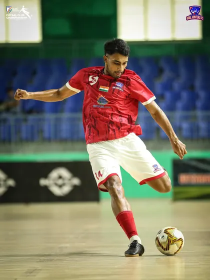 A player taking a powerful shot on goal.