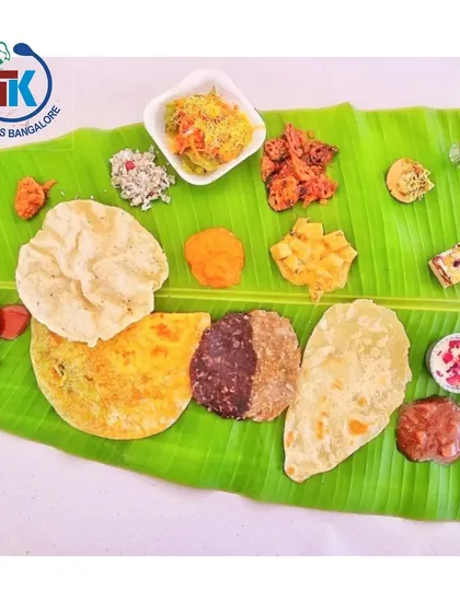 This is what a proper Karnataka wedding feast looks like on a banana leaf. You can see our special 50-50 Holige, a variety of palyas, kosambari, and crispy snacks. I make sure every oota is a grand and authentic experience.