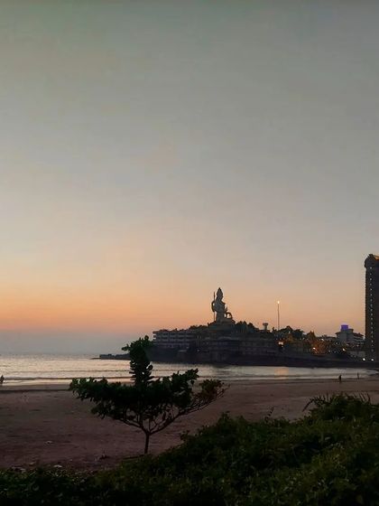 A serene sunset at Murudeshwar beach, with the Shiva statue in the distance.