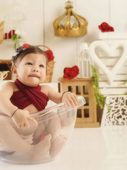 A curious glance during her bohemian first birthday session. The red and white props create a lovely, warm contrast.
