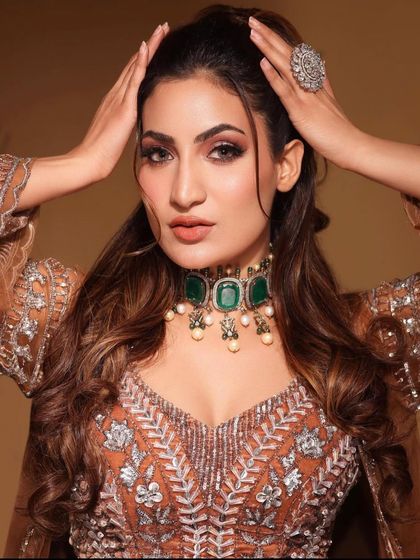 A confident pose by the model, her hands framing her face and showing off the large AD ring.