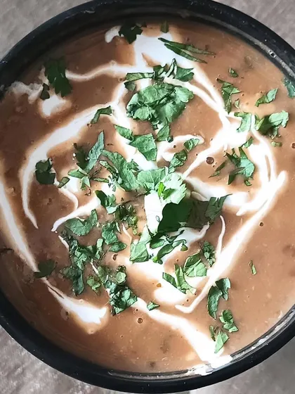 A close-up of my creamy Dal Makhni, garnished with fresh cream and coriander. It's slow-cooked for hours to get the authentic flavor.