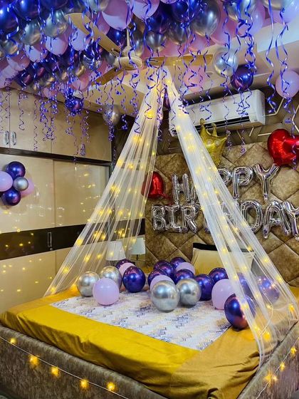 Another view of the purple canopy setup, showing the "Happy Birthday" foil balloons and crown accent.