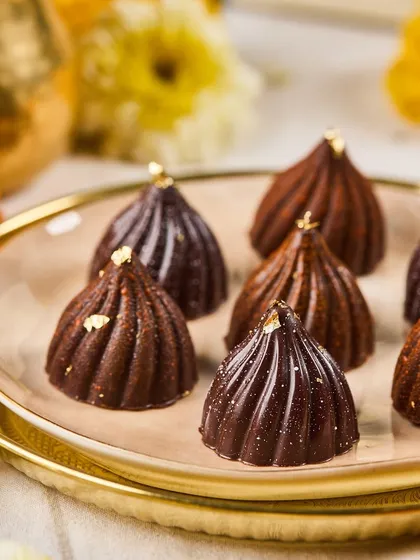 A close-up of our classic Modak Bonbons, filled with coconut and jaggery. They are a modern tribute to a timeless festive sweet.