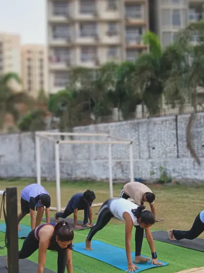 A deep lunge stretch to open up the hips. Our members enjoy the benefits of outdoor yoga and mobility work in our spacious training area.