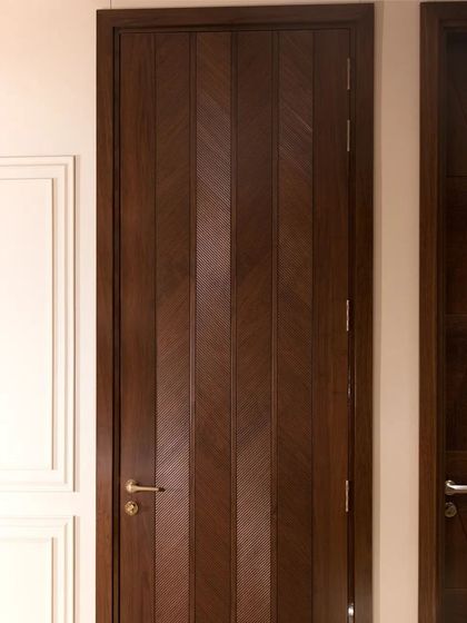 A full view of an American walnut veneer door with a ripped flute chevron design. The pattern adds a sense of height and dynamic energy to the door.