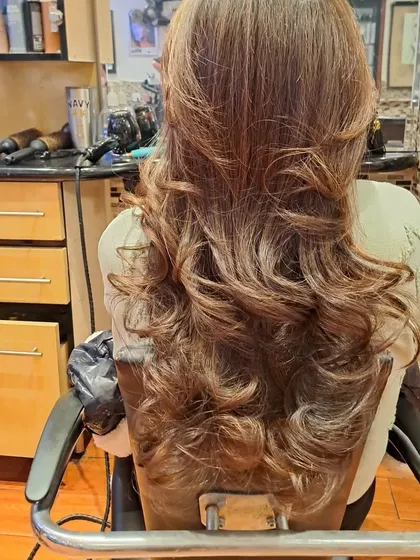 This angle shows the beautiful cascade of layers and curls from the back. This is a timeless salon blowout style.