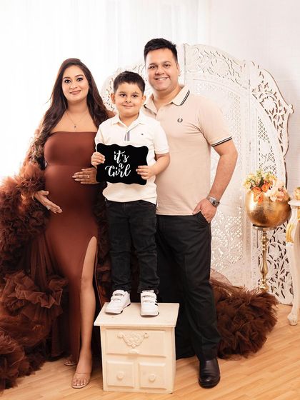 The whole family together for a maternity announcement. The big brother proudly holds the "It's a Girl" sign, making for a memorable family portrait.