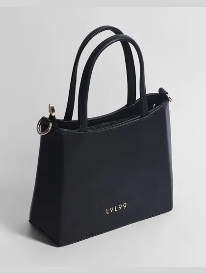 A crisp, three-quarter view of a black handbag, showcasing its minimalist design and branding.