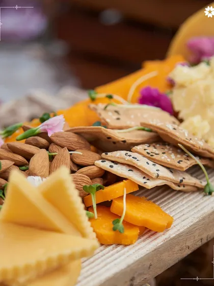 A close up of our grazing board, showing the beautiful textures of artisanal crackers, nuts, and cheeses. Each element is chosen for its quality and how it complements the others.