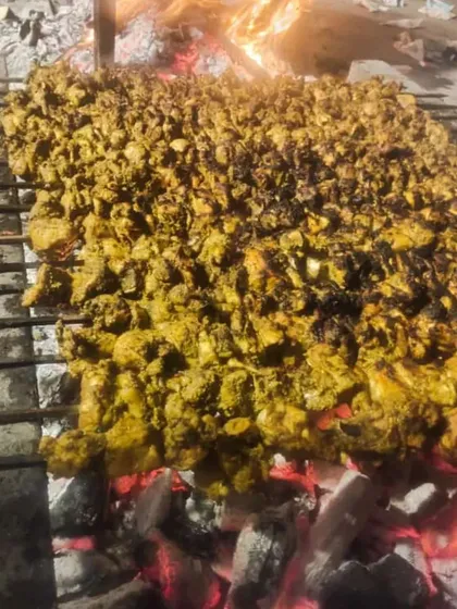 Chicken kebabs getting their smoky flavour directly from the coals. I don't use shortcuts. This is how you get that real barbecue taste for your event starters.