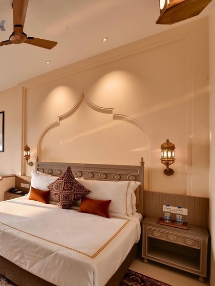 This bedroom at The Fern Sattva Resort showcases our use of local craftsmanship and motifs. The arched wall detail and traditional lanterns create a sense of place, grounding the modern comforts of the room in its cultural context.