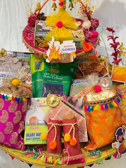 Celebrate the spirit of Lohri with my curated hampers. This one is overflowing with traditional treats like gajak, dates, and popcorn, all packed in festive brocade potlis.