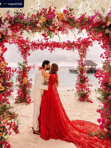 A kiss under a beautiful floral arch. This picture captures the romance of the day, with the bride's look being both elegant and effortlessly beautiful.
