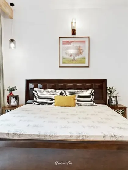 A bright guest bedroom with a pop of color from the light blue wardrobe. The simple wooden bed and warm lighting create a welcoming and comfortable space for visitors.
