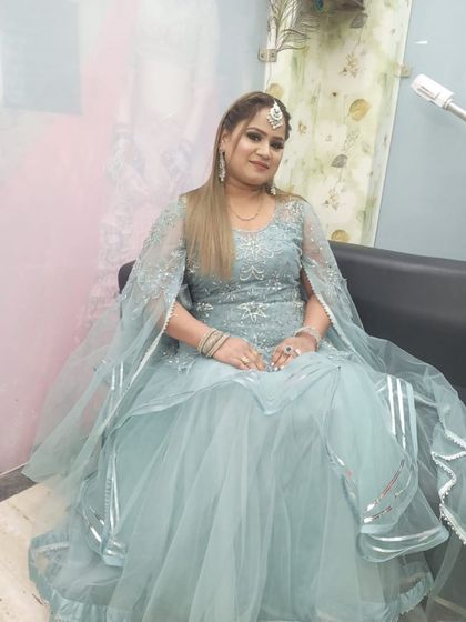 A client looking serene in a powder blue gown with silver work and a cape-style dupatta. A graceful rental choice for an evening function.