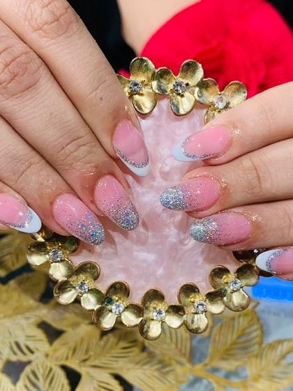 A classic glitter French manicure with a silver glitter gradient on the tips for a sparkling finish.