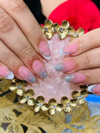 A classic French ombre look with a soft pink base fading into white tips, enhanced with a beautiful silver glitter fade.