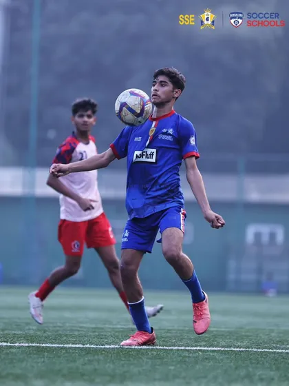 A U17 player demonstrates excellent ball control, chesting the ball down under pressure. We focus on developing technical skills that stand up in competitive matches.