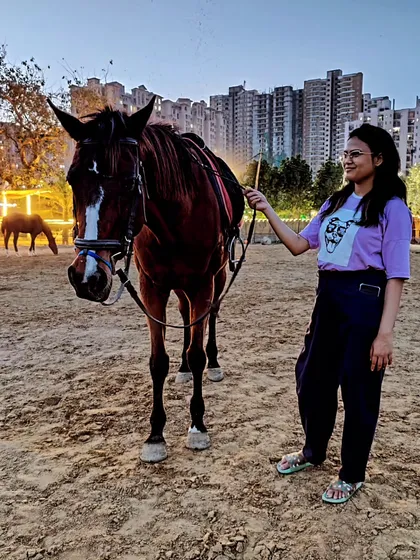 A client leads her horse through the arena at dusk. This type of shot is perfect for lifestyle and fashion photography, showcasing a connection with the animal.