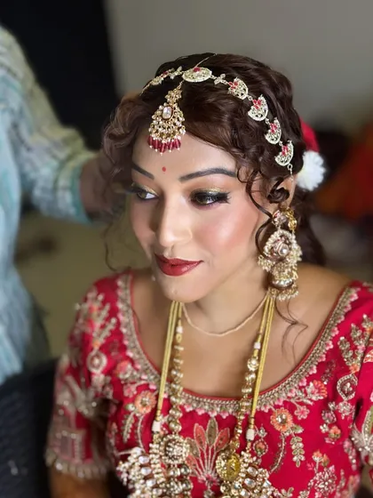 A close-up of the bride's makeup, showcasing the intricate eye work and the beautiful matha patti. The look is a perfect blend of tradition and modern glamour.