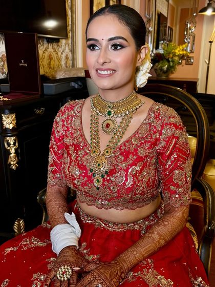 My beautiful bride Anushree, looking radiant and happy in her classic red bridal lehenga. The makeup is clean and timeless, with a focus on her bright smile.