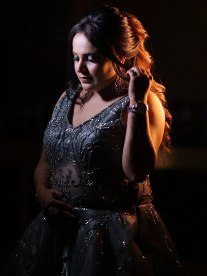 A classic portrait of the bride Gunjan, looking down thoughtfully. The soft lighting highlights her hair and the intricate details of her gown, creating a serene and beautiful image.