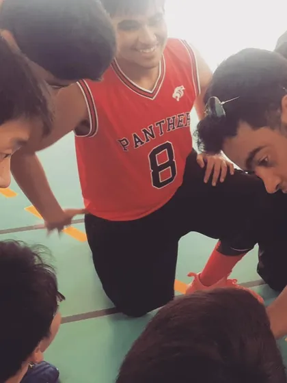 A team huddle during a timeout, where I am giving strategic advice to our young players. These moments of guidance and team bonding are crucial for on-court success and building player confidence.