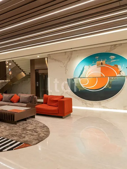 A different view of the living space, highlighting the large-scale, custom circular artwork that acts as a vibrant focal point. Its reflection on the polished marble floor adds another layer of visual interest, demonstrating how art can be integrated to define and energize a room.