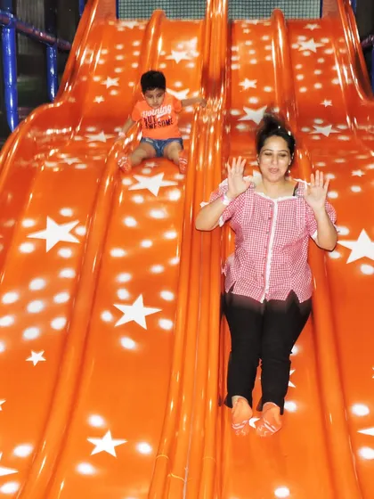 A mother and her son share a fun moment on our double slide. My play area is designed for parents to join in the fun, creating shared experiences and happy memories.