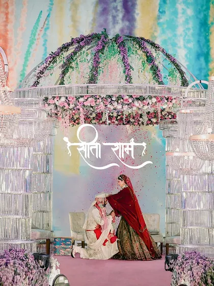 A moment of tradition and love. The groom bows as the bride places the varmala, set against a custom 'Sita Ram' backdrop at their Goa wedding.