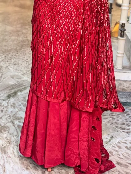 The lower part of the 'LAALPARI' saree features a unique layered design, adding volume and a contemporary edge to the traditional drape.