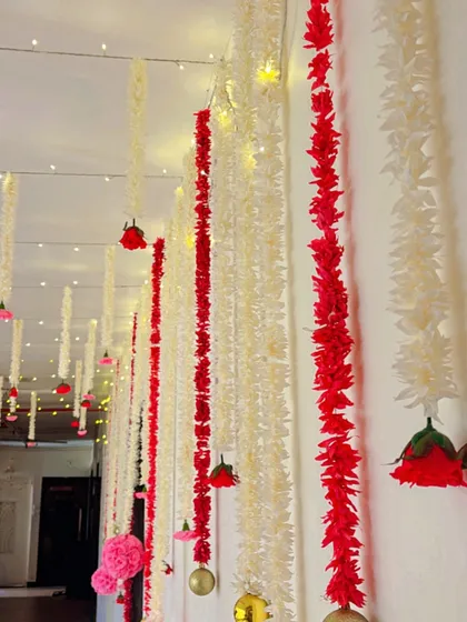 For this home decor, I used strings of artificial red and white flowers, interspersed with fairy lights, to create a dramatic and festive ceiling treatment. It's an effective way to transform a hallway or room.