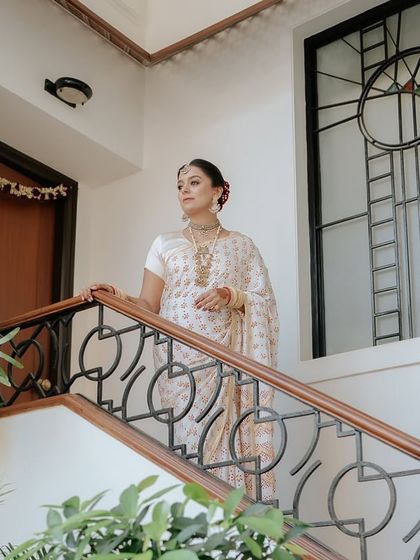 A series of portraits of a bride in a beautiful, traditional white and red saree, capturing her elegance, emotion, and moments with her family.