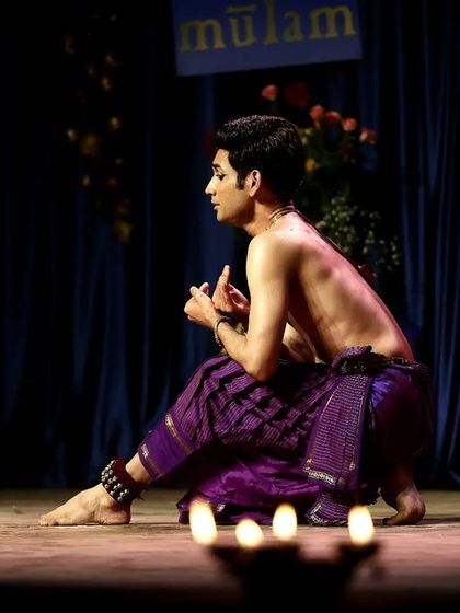 A moment of quiet contemplation during a performance, surrounded by the gentle light of diyas. This setting is perfect for intimate gatherings where the focus is on subtle expression.
