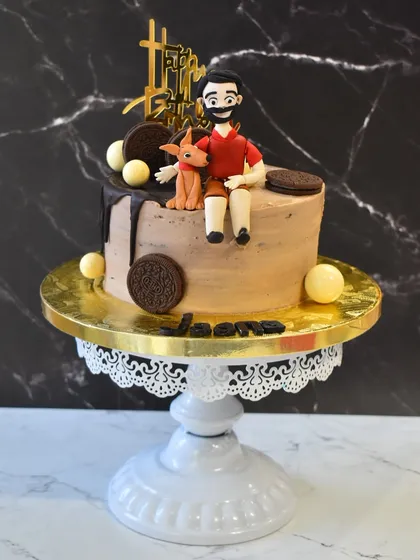 A paw-some chocolate truffle cake for a dog lover. It's topped with a custom, hand-sculpted figurine of the birthday person and their beloved furry friend.