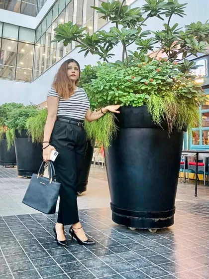 A classic black-and-white striped top paired with high-waisted black trousers and heels. This demonstrates a polished, semi-formal look suitable for various settings.