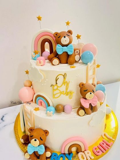Oh baby. A beautiful two-tier gender reveal cake with teddy bears, rainbows, and a "Boy or Girl" message.