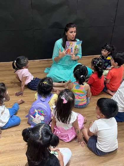Even our storytelling sessions get a festive makeover for Holi. Here, I am sharing a colorful story with the children, all sitting together on the floor, ready for the fun to begin.
