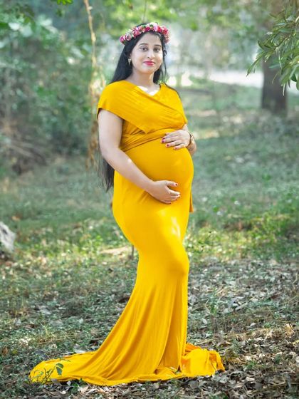 A standing portrait in a sunlit clearing. The vibrant yellow of the gown stands out beautifully against the greens and browns of the forest floor.