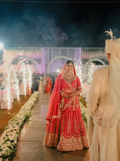 The bride's grand entrance. The groom watches as his bride walks down an aisle lined with flowers and cold pyro fireworks.