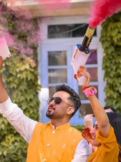 The celebration kicks off with a bang! The couple uses color smoke cannons to start their Haldi party in style.