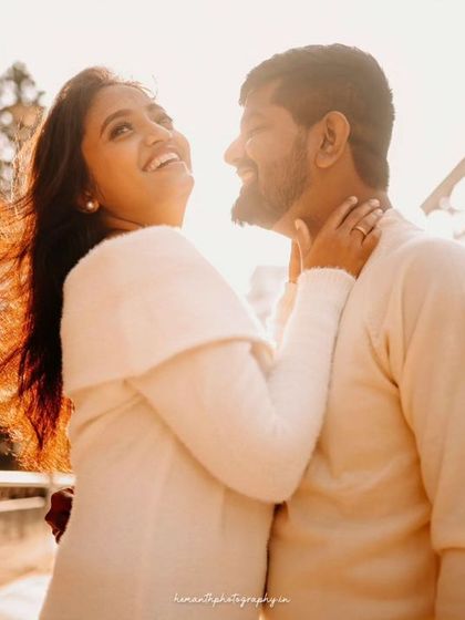 Another copy of the same sun-drenched, happy moment between the couple on a city bridge.