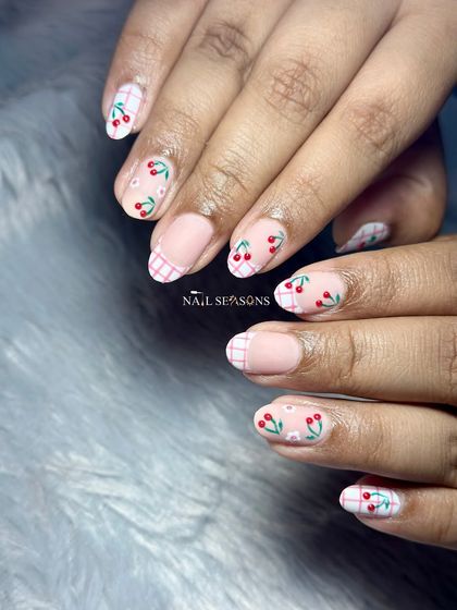 The cutest combo ever. This design features hand-painted cherries and pink checkerboard French tips.