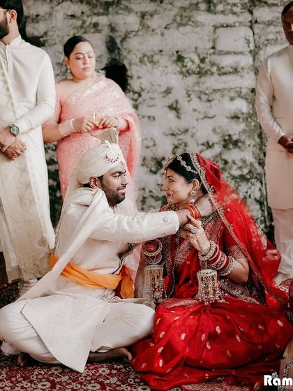 An intimate moment during the temple wedding ceremony, where the groom gently holds his bride's hand. This shot captures the sanctity and emotion of their vows in a sacred setting.