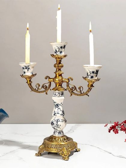 A beautiful candelabra that combines a vintage brass structure with blue pottery candle holders. This piece is a perfect fusion of styles, ideal for creating a dramatic and elegant centerpiece.